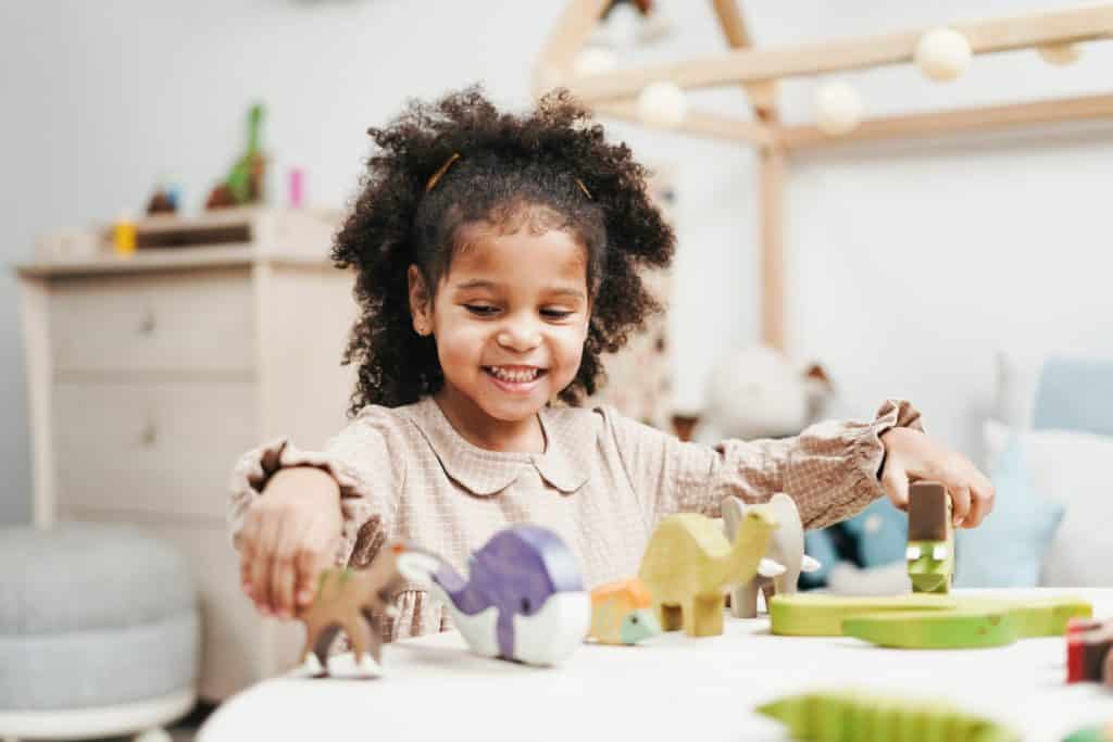 Dual- heritage girl with natural hair playing with animals