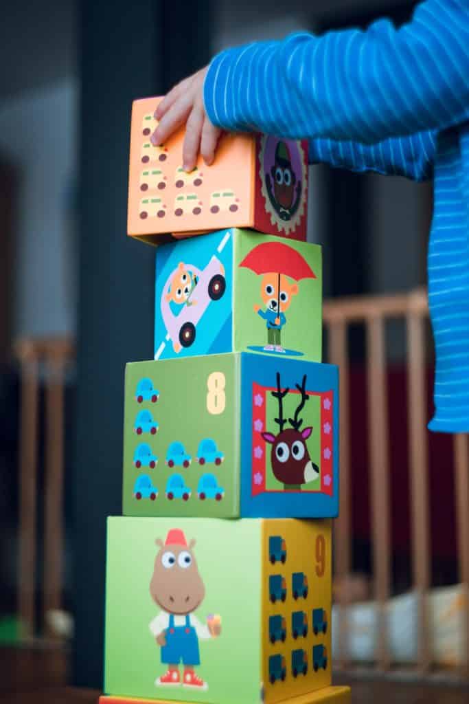 White child's hands stacking blocks