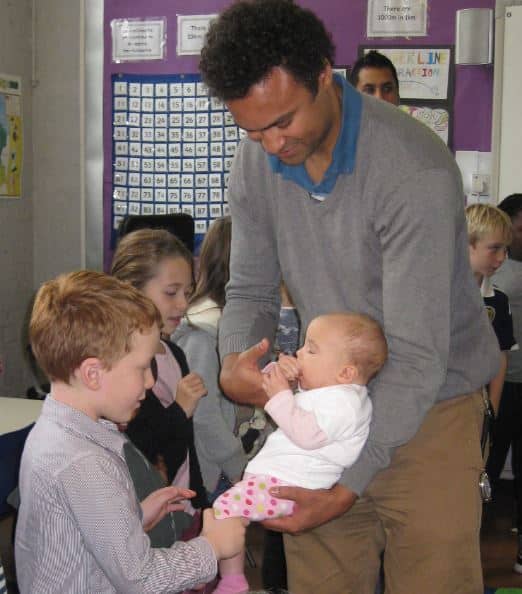 Dad showing his baby to school pupils