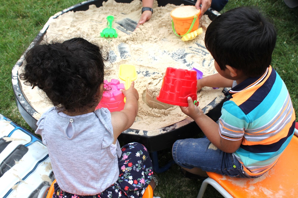 Asian boy and girl making sandcastles on a sand tray