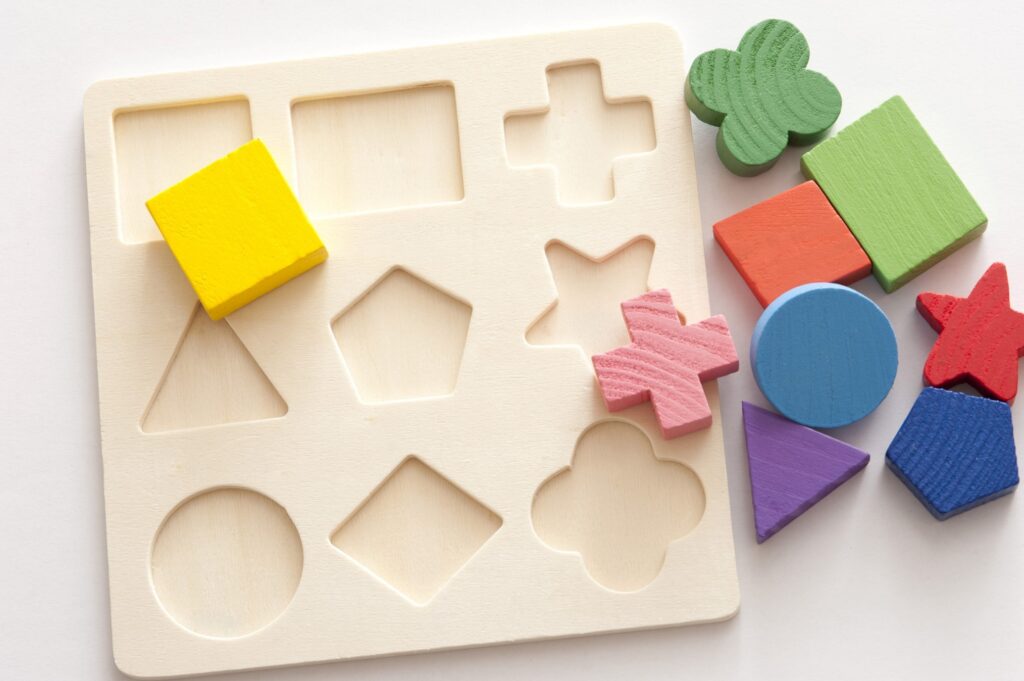 wooden flat shape sorter, with coloured shapes